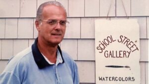 Photo of Richard Secor by sign of his gallery, School Street Gallery 